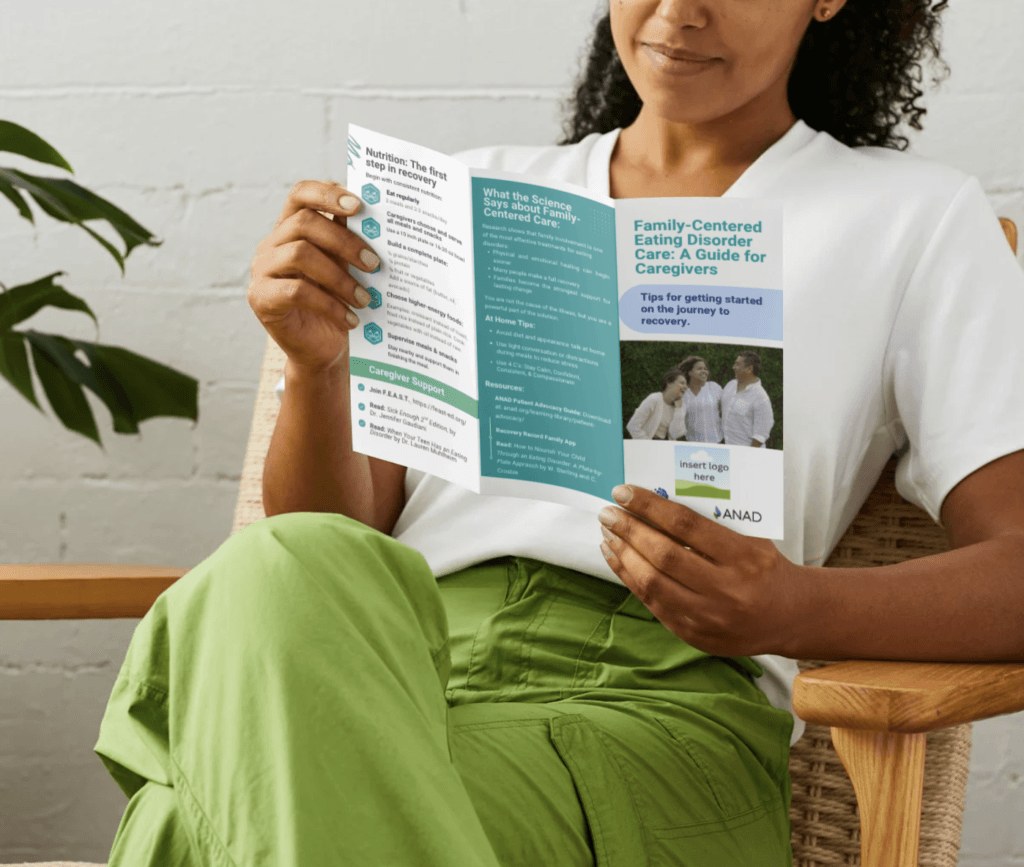 woman in white shirt and green pants reading the trifold brochure